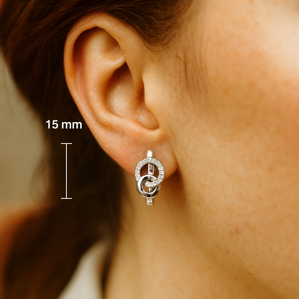 A pair of silver hoop earrings with embedded green zircon stones, displayed against a white background.